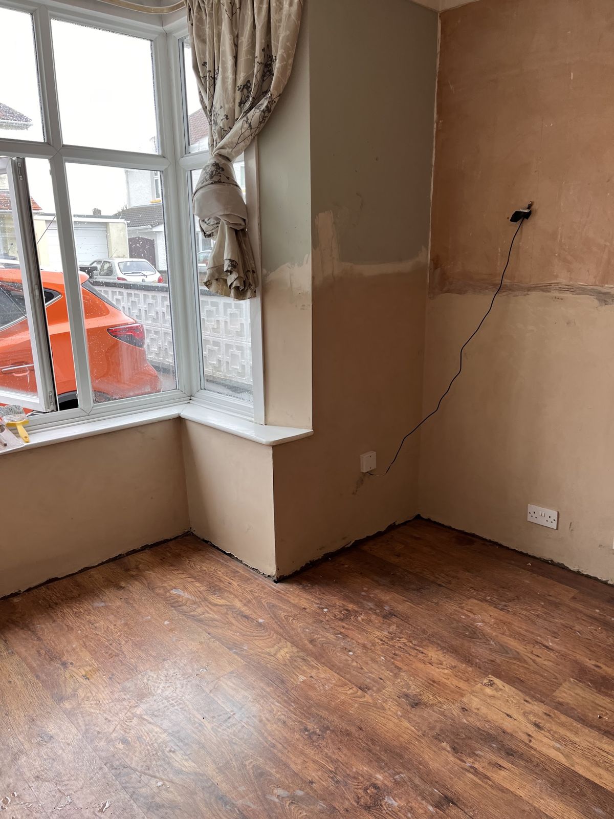A bay-window room after re-plastering, with new plaster to dado height
